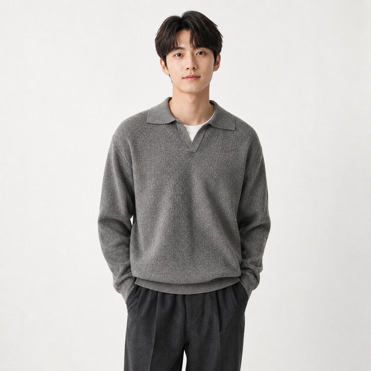 Man wearing a gray sweater and dark pants on a white background
