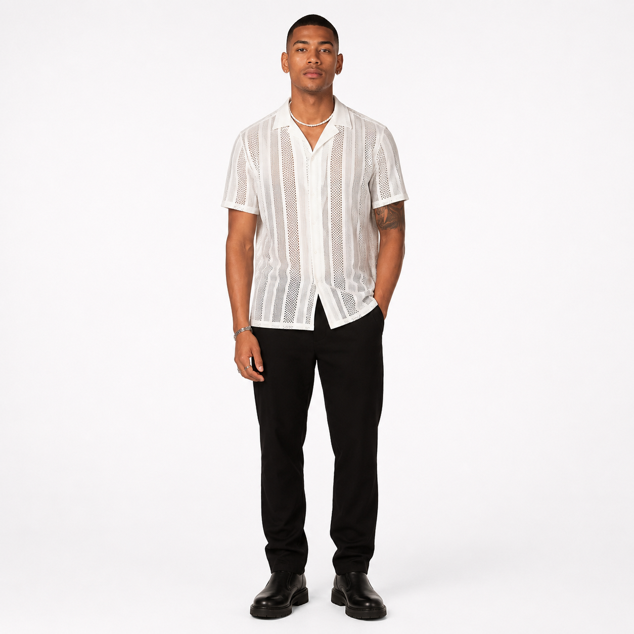 Man wearing a white textured shirt and black pants on a white background