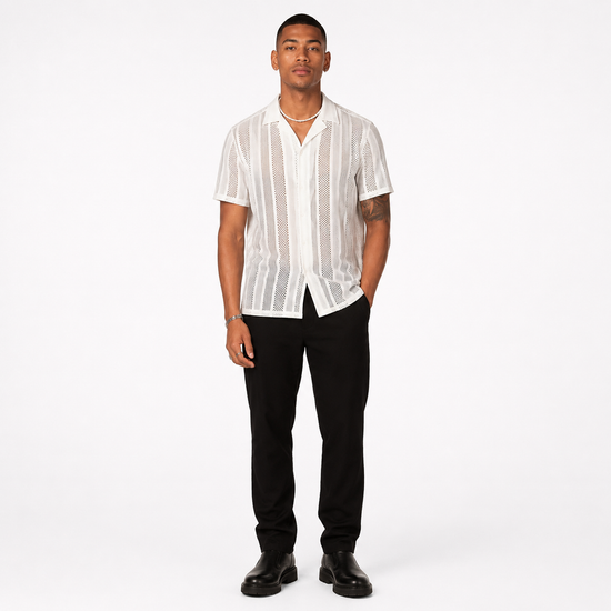 Man wearing a white textured shirt and black pants on a white background