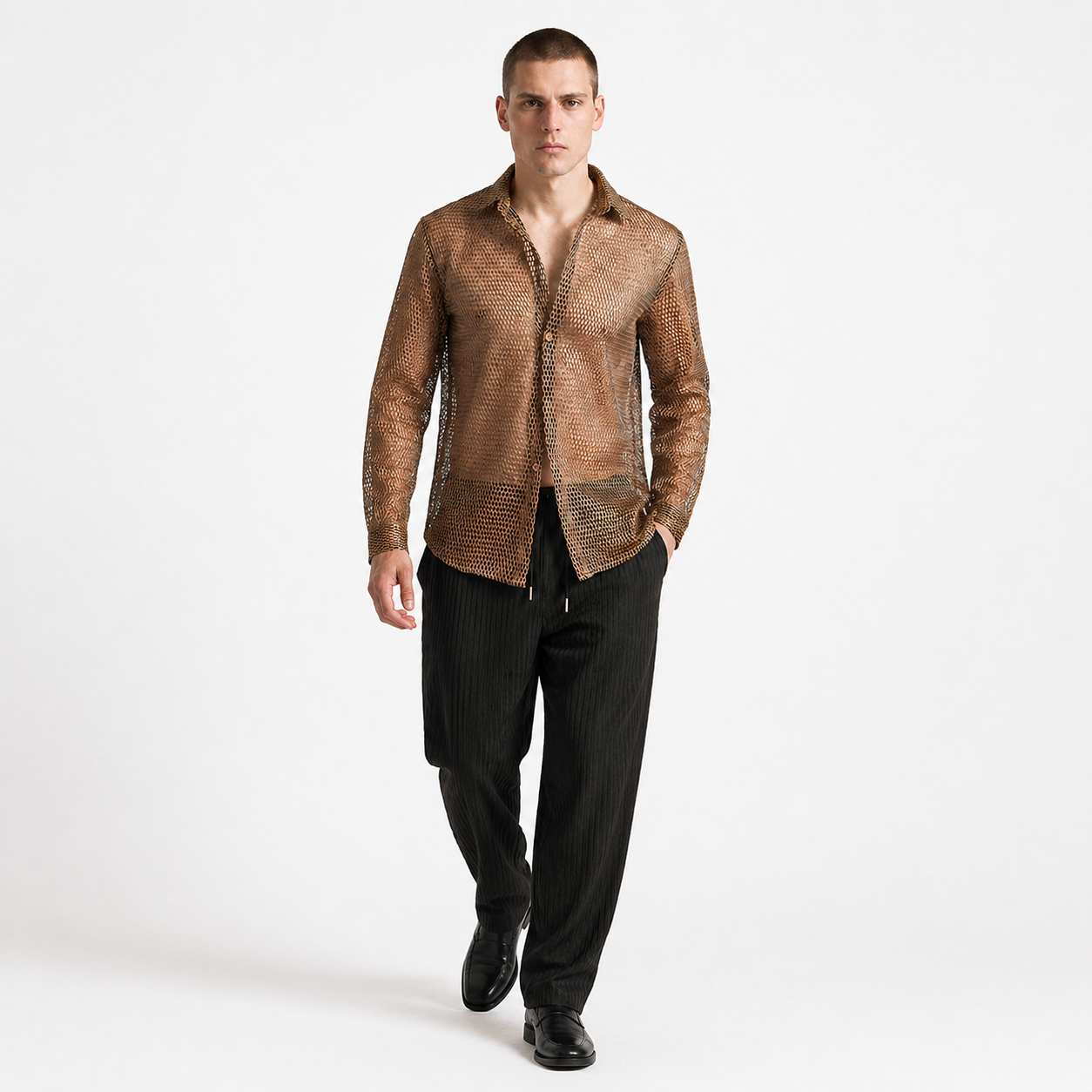 Man wearing a brown patterned shirt and black pants on a white background