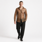 Man wearing a brown patterned shirt and black pants on a white background