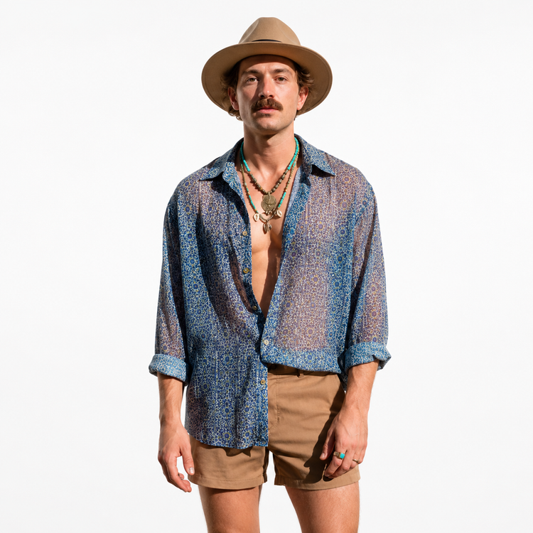 Man wearing a patterned shirt, beige shorts, and a hat on a white background