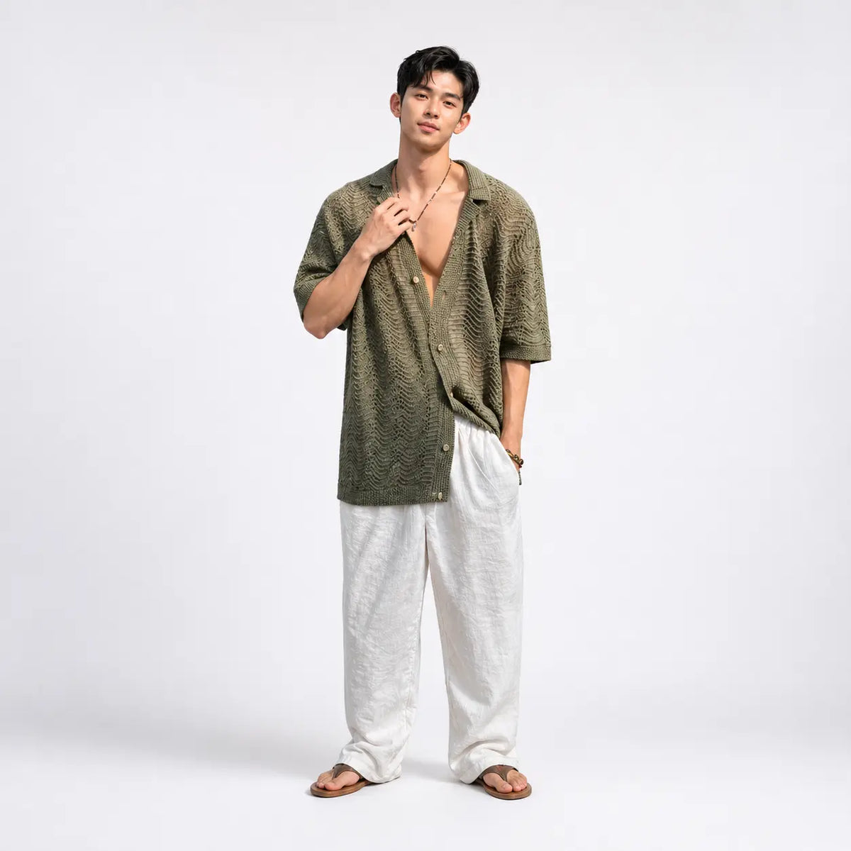men's green cuban collar knit cardigan in loose fit displayed on a model adjusting necklace