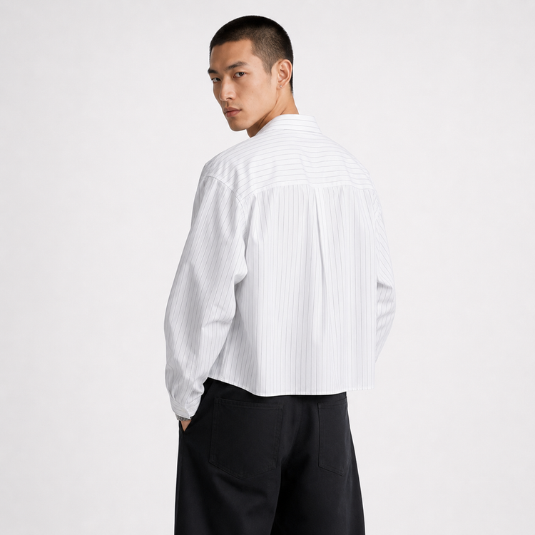 Person wearing a white button-up shirt and black pants on a white background