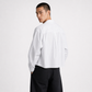 Person wearing a white button-up shirt and black pants on a white background