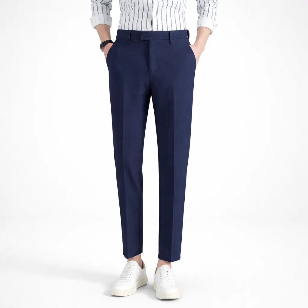 Navy blue pants worn with a white and blue striped shirt on a white background