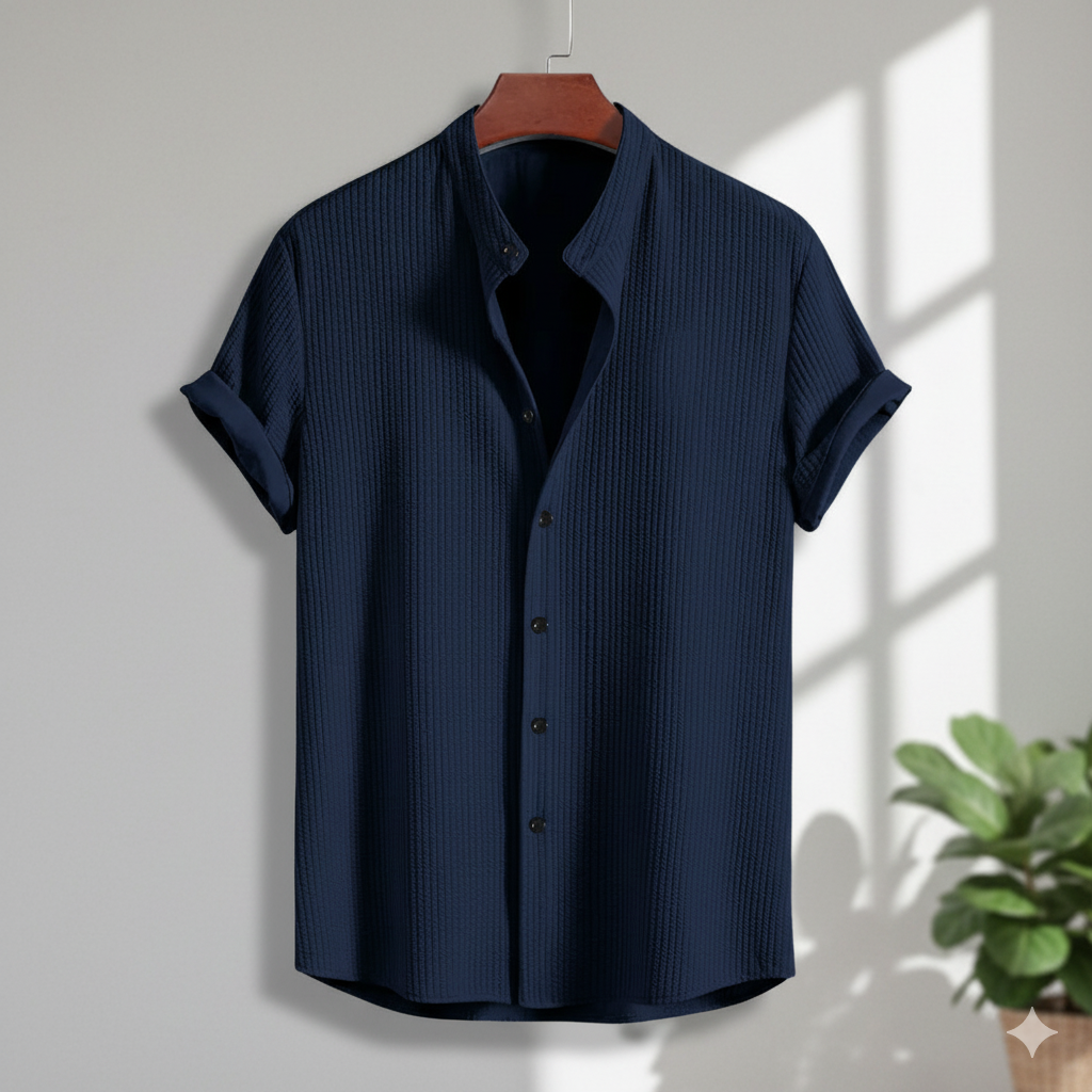 Navy blue short-sleeve shirt on a hanger with a plant in the corner