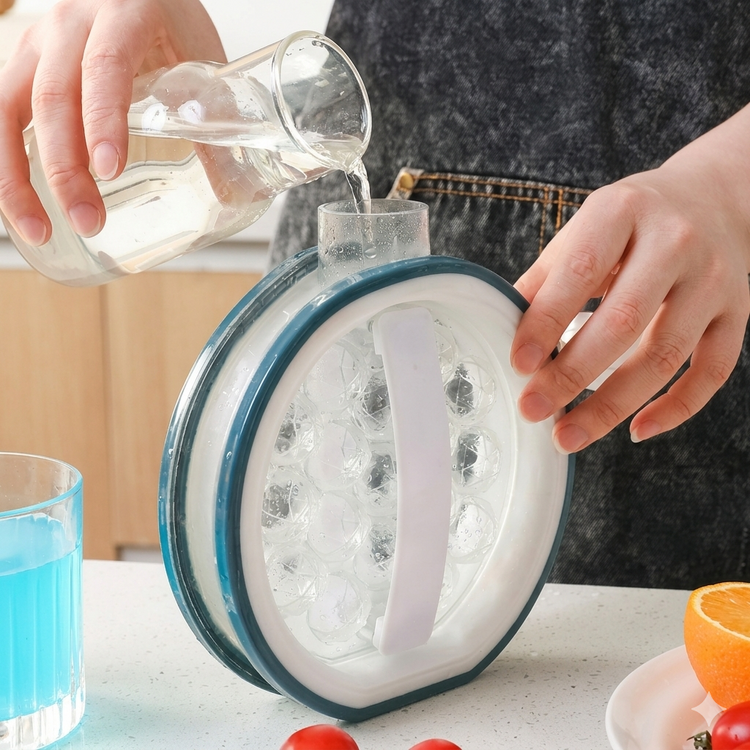 Person pouring water into a transparent container with blue rim on a kitchen counter.