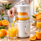 Person using a manual juicer to extract orange juice in a kitchen setting SIMPLE WHITE