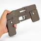 Hand holding a metallic gun-like object on a white background