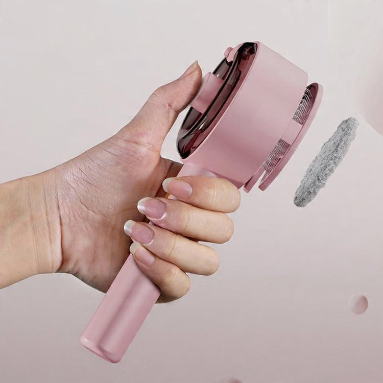 Pink handheld hair care device with brush and nozzle on a white background