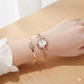 Rose gold watch and bracelet on a wrist with a light background
