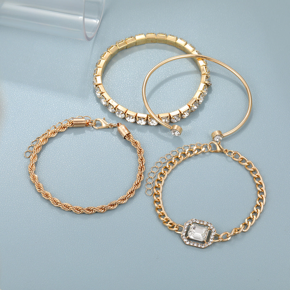 Set of gold hoop earrings and bracelets on a light blue background