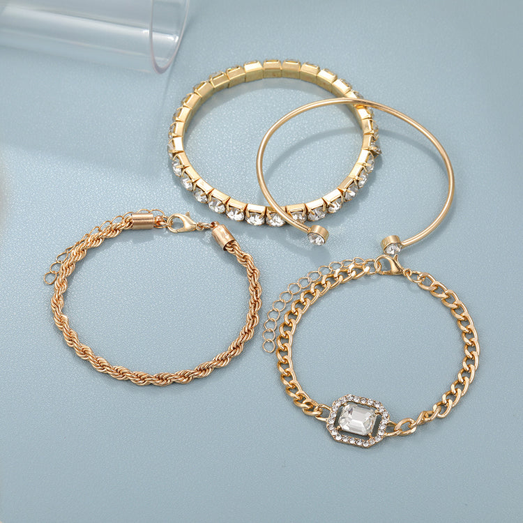 Set of gold hoop earrings and bracelets on a light blue background
