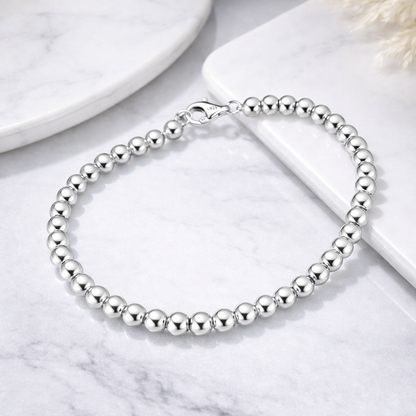 Silver beaded bracelet on a marble surface