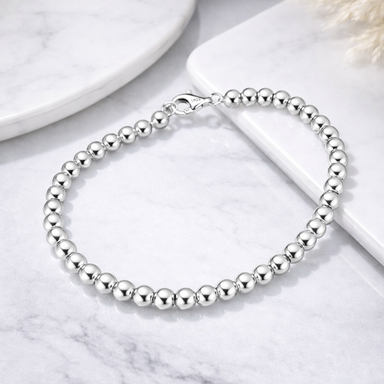 Silver beaded bracelet on a marble surface