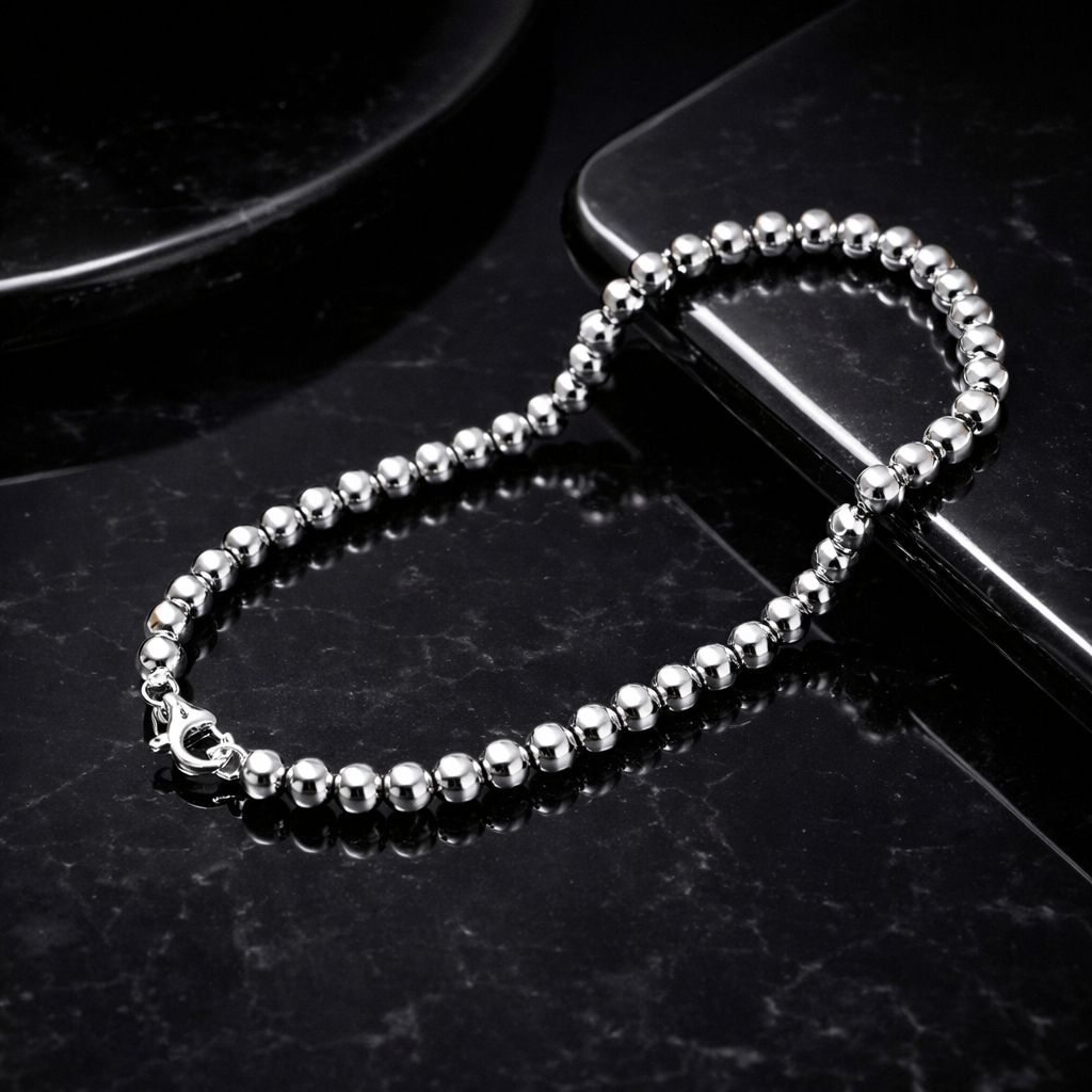 Silver beaded chain on a black surface