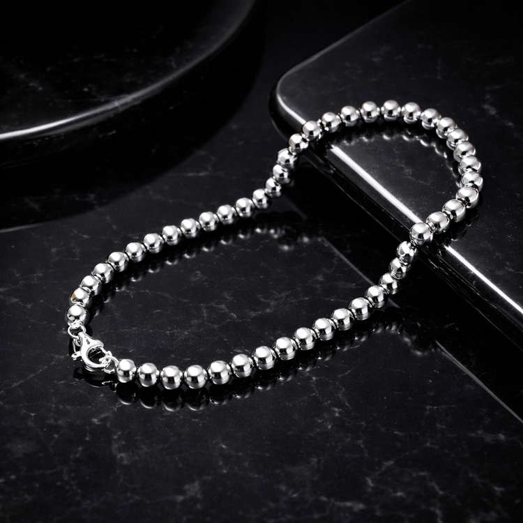 Silver beaded chain on a black surface
