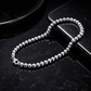 Silver beaded chain on a black surface