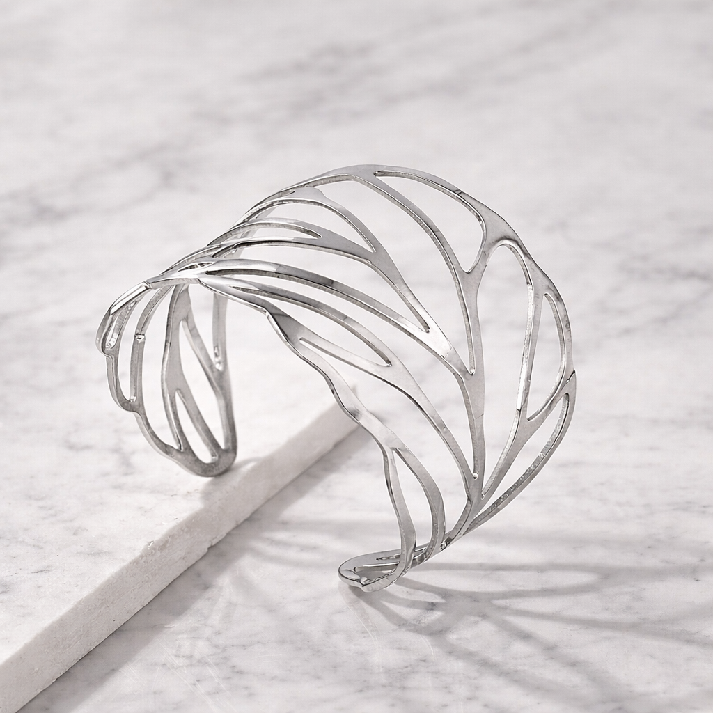 Silver cuff bracelet on a light gray surface