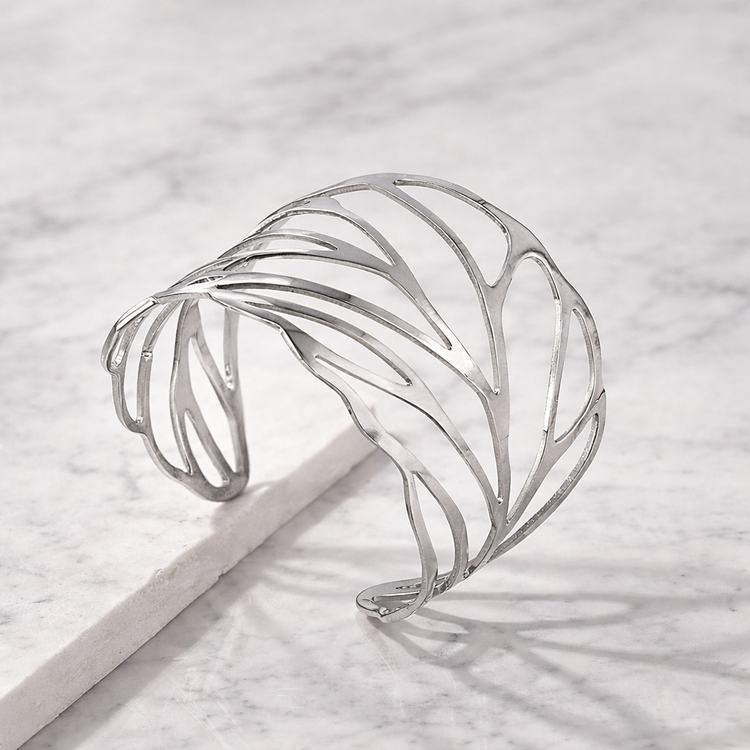 Silver cuff bracelet on a light gray surface