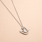 Silver necklace with a dove-shaped pendant on a beige background