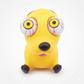 A yellow cartoon dog toy with oversized white eyeballs featuring red veins, a black nose, and black paws, photographed on a clean white background.