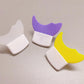 Three silicone moon-shaped coasters on a light gray surface