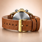 Watch with brown leather strap and gold casing on a beige background