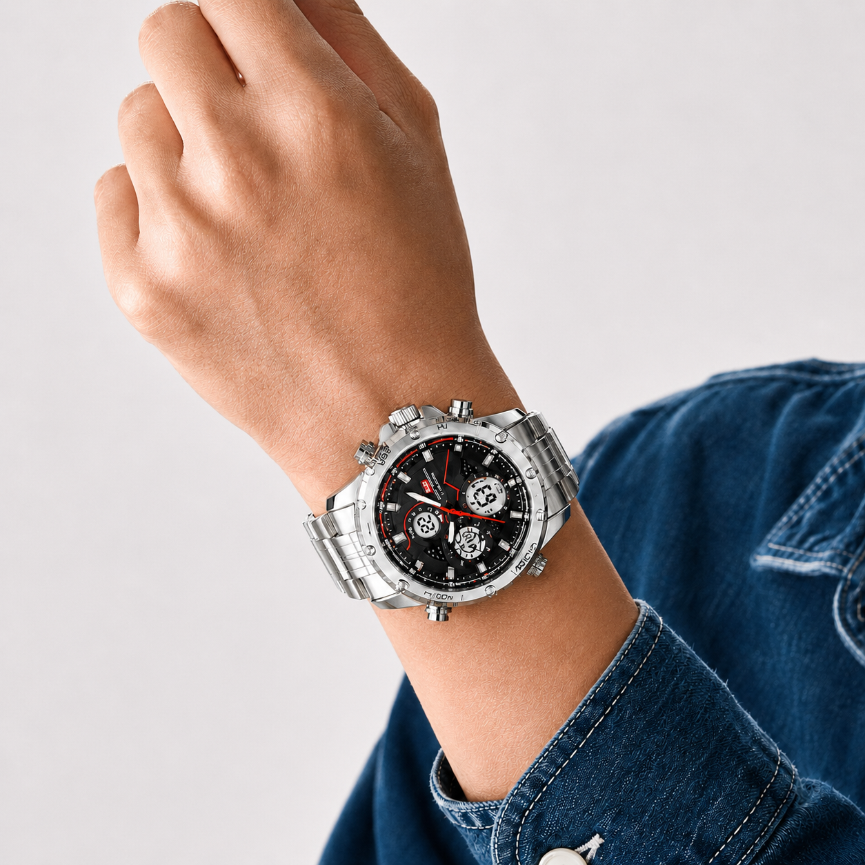 Hand wearing a silver watch with a black face on a light gray background