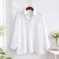 White shirt on a hanger against a white background
