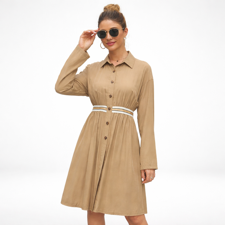 Woman wearing a beige dress with a belt on a white background