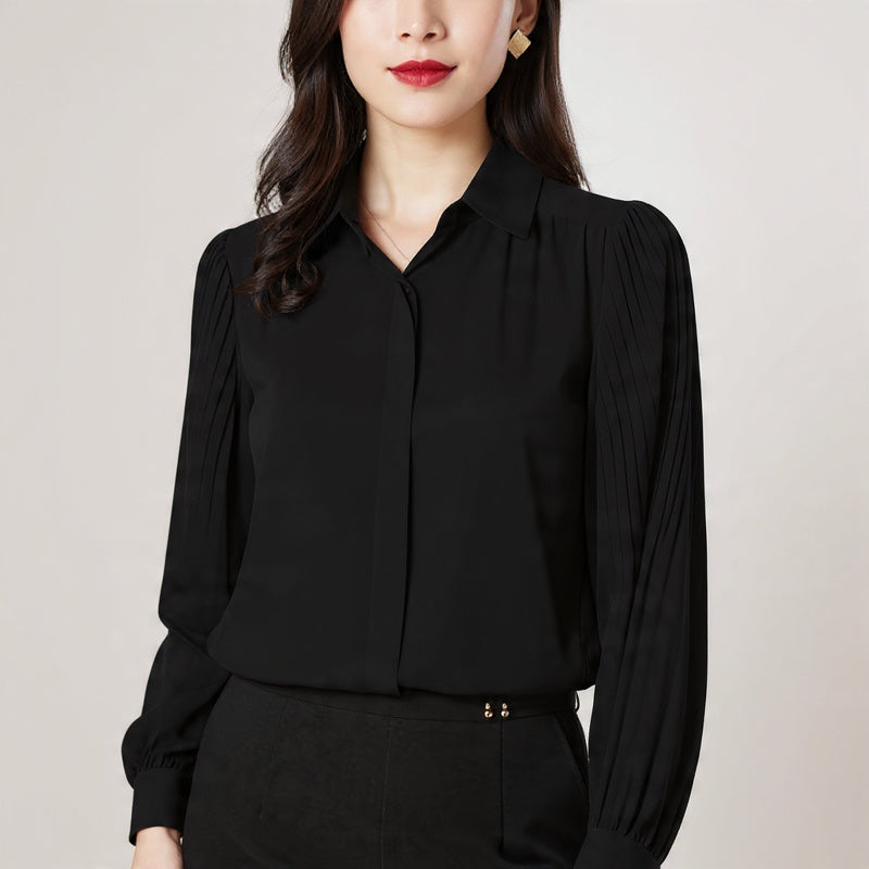 Woman wearing a black blouse against a plain background