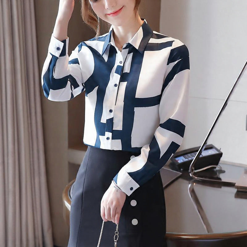 Woman wearing a blue and white patterned blouse with a blurred background