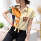Woman wearing a colorful abstract patterned blouse with a blurred background.