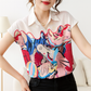 Woman wearing a colorful abstract patterned blouse with a blurred background
