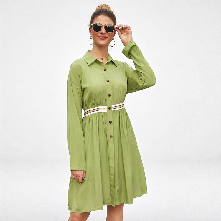 Woman wearing a green dress with a belt on a white background