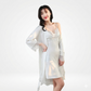 Woman wearing a white lace nightgown with a matching robe on a white background