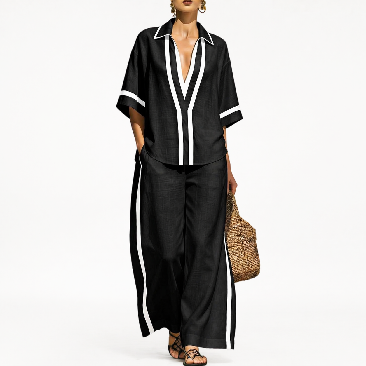 Woman wearing a black outfit with white trim on a white background