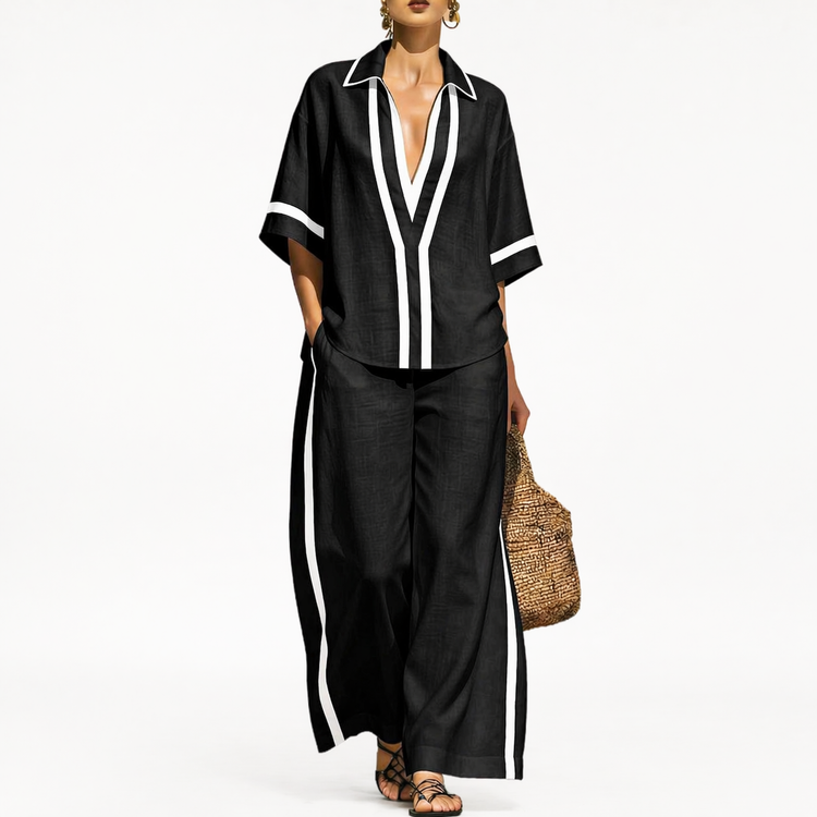 Woman wearing a black outfit with white trim on a white background
