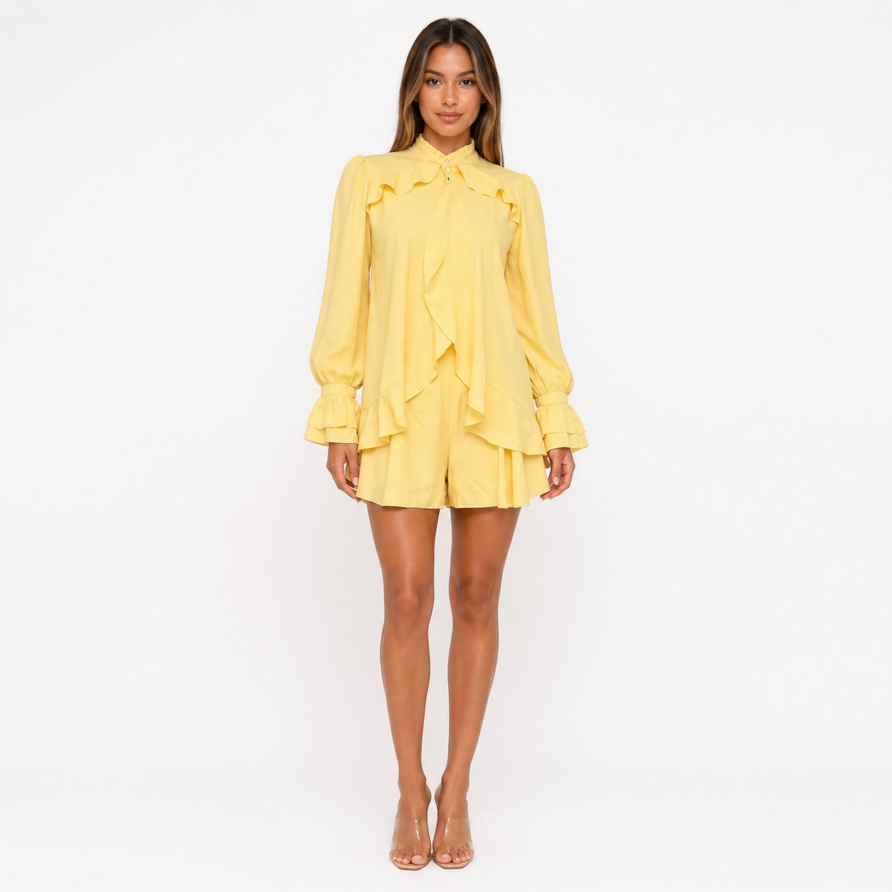 Woman wearing a yellow dress with ruffled details on a white background
