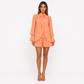 Woman wearing an orange ruffled dress on a white background