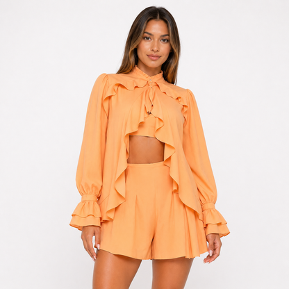 Woman wearing an orange outfit with ruffled details on a white background