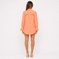Woman wearing an orange dress on a white background