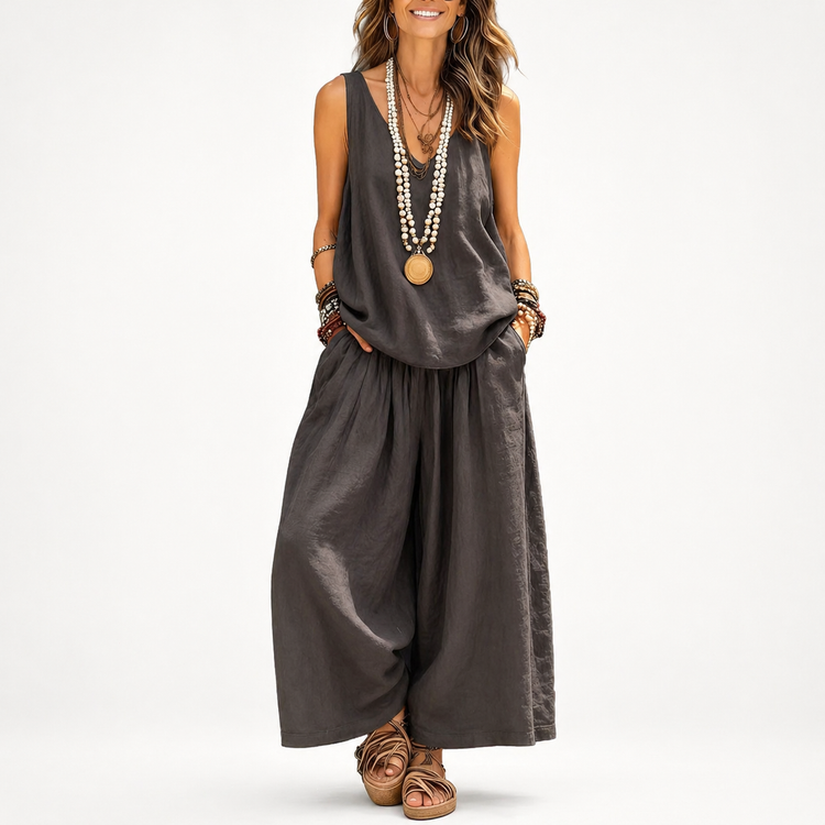 Woman wearing a gray sleeveless top and wide-leg pants on a white background
