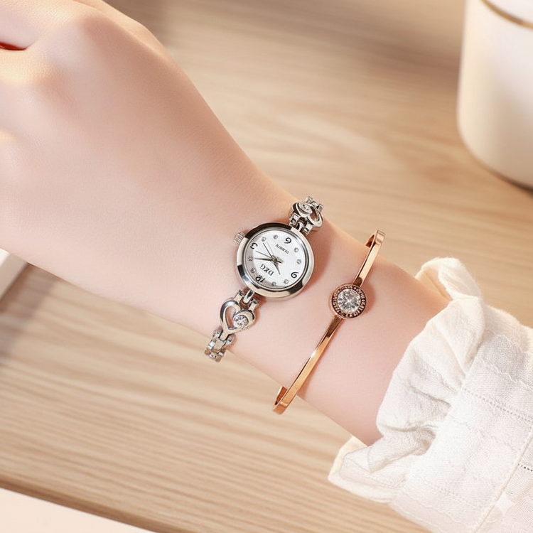 Wrist with silver watch and rose gold bracelet on a wooden surface