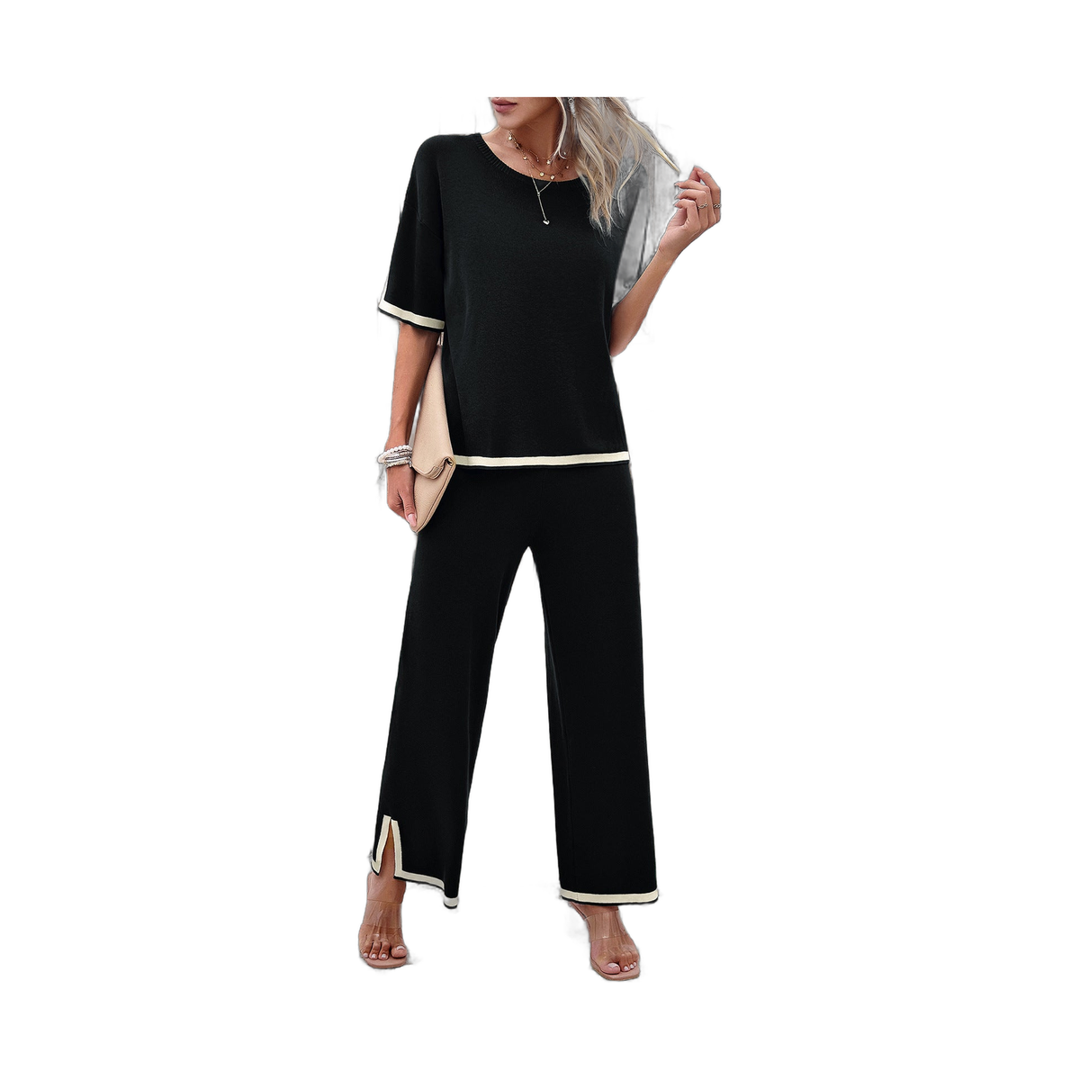 model in beige outfit with black accents posing by textured wall and steps