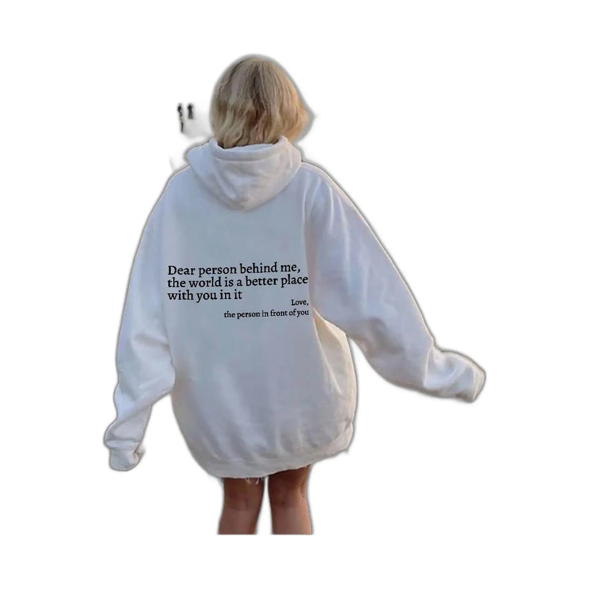 person wearing a white hoodie with an uplifting message walking near the ocean