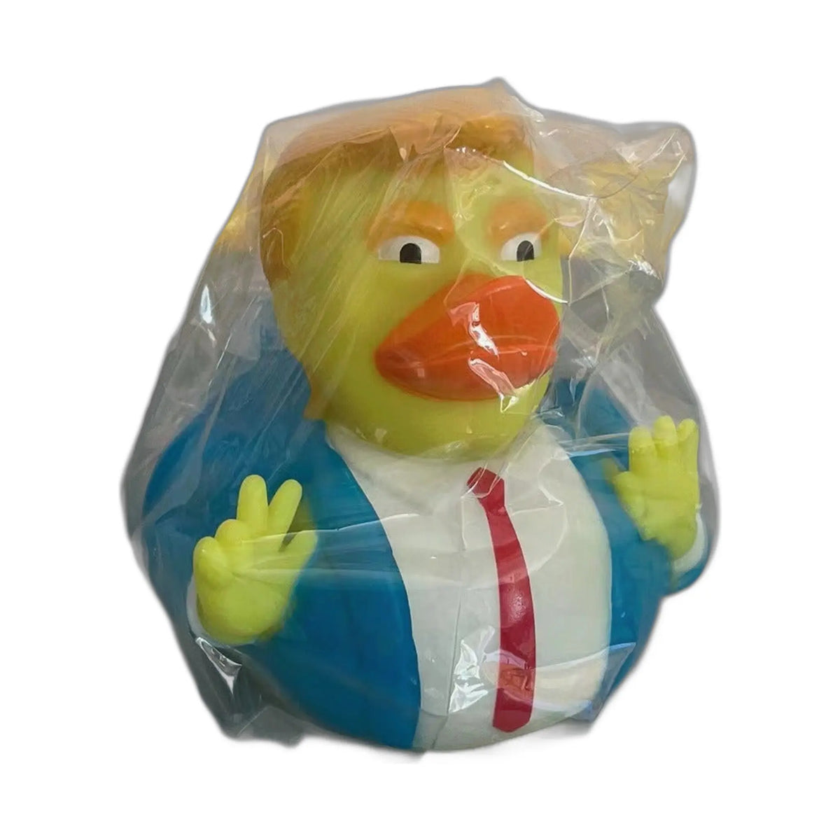 Squeaky duck bath toy, a yellow duck in blue suit, white shirt, red tie, yellow-orange styled hair, left hand in peace s