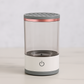 cylindrical device with clear center, gray top and bottom, and rose gold band on a white background